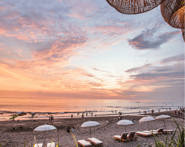 Beach with sun loungers and umbrellas at sunset
