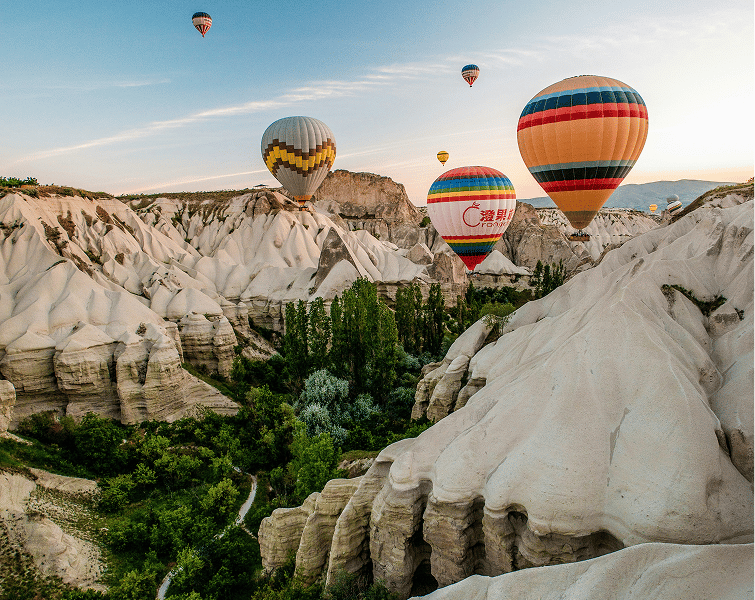 Hot air balloons over a valley of rock formations