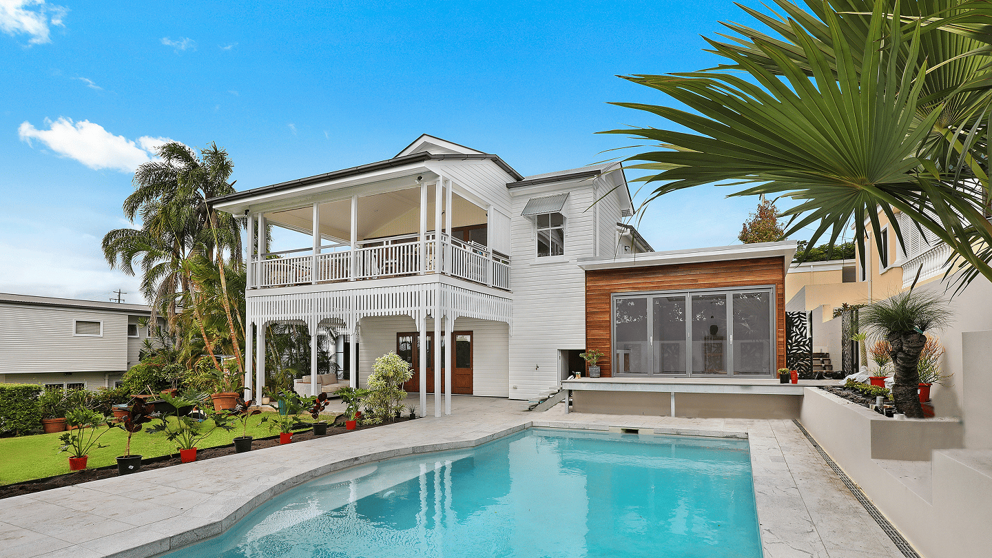 Villa and swimming pool framed by palm trees